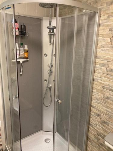 une douche avec une porte vitrée dans une salle de bain dans l'établissement Belle maison 3 chambres avec jardin et piscine Saint-Pierre d'Oléron OCEAN LILI's EYES, à Saint-Pierre-dʼOléron