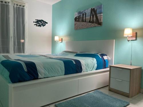 une chambre avec un grand lit aux murs bleus dans l'établissement Belle maison 3 chambres avec jardin et piscine Saint-Pierre d'Oléron OCEAN LILI's EYES, à Saint-Pierre-dʼOléron