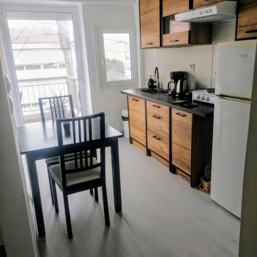a kitchen with a table and chairs and a refrigerator at 55sm apartment Voula 4pax in Athens