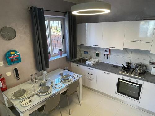 a kitchen with white cabinets and a table with chairs at Luxury Apartment with Hot Tub in Is-Swieqi