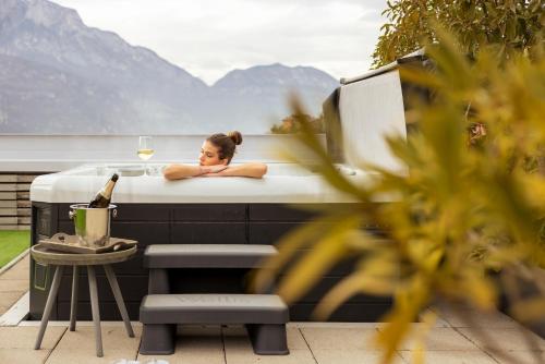 a woman laying in a bath tub with a glass of wine at La Villa - Luxury Guest House in Trento