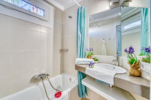 a bathroom with a tub and a sink and a mirror at Ideal Property Mallorca - Dali 127 in Port d'Alcudia