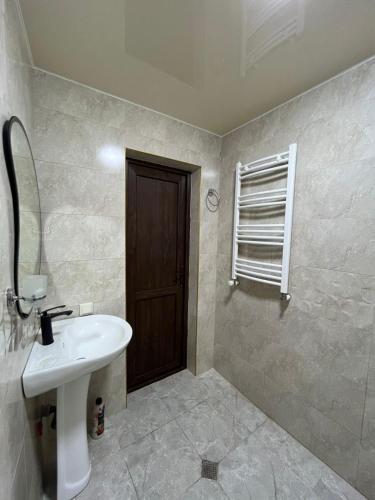 a bathroom with a sink and a mirror and a door at Garden house in Akhaltsikhe