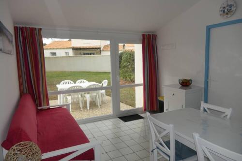 a kitchen with a table and chairs and a window at Maison 4 personnes avec piscine in Dolus d'Oléron