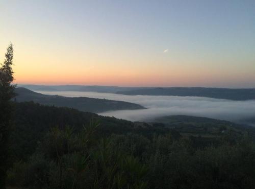a view of a foggy valley with the sun setting in the background at Villa Bella in Grožnjan