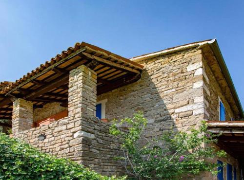 a stone house with a brick wall and a roof at Villa Bella in Grožnjan