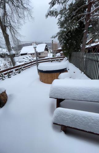 a yard covered in snow with a couple of benches at Chalúpka pod lipami in Čadca