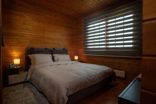 a bedroom with a large bed and a window at Σαλέ κοντά την Νάουσα in Lefkádia