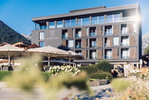 a large building with umbrellas in front of it at Seehotel Einwaller - adults only in Pertisau
