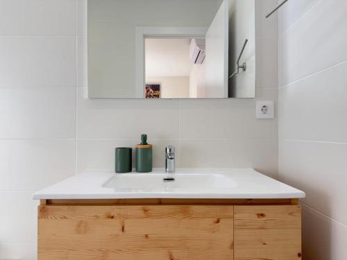 Un baño con un lavabo blanco y un espejo. en Villa Leonardo, en Castelldefels