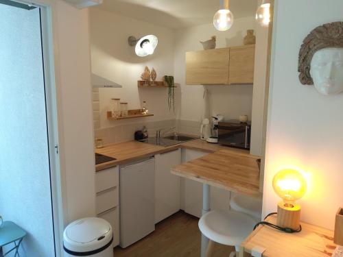 une cuisine avec des armoires blanches et un comptoir en bois dans l'établissement Studio - Les Voiles de La Baule, à La Baule