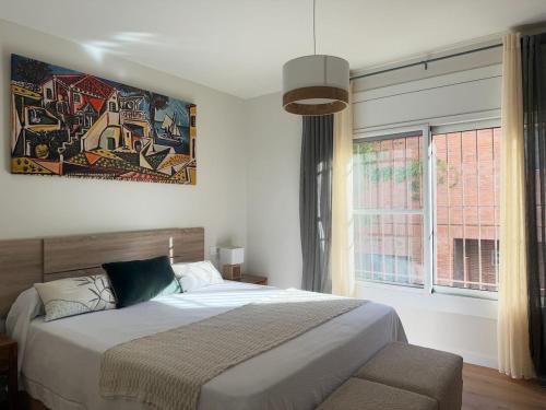 Un dormitorio con una cama y una ventana grande en Villa Leonardo, en Castelldefels