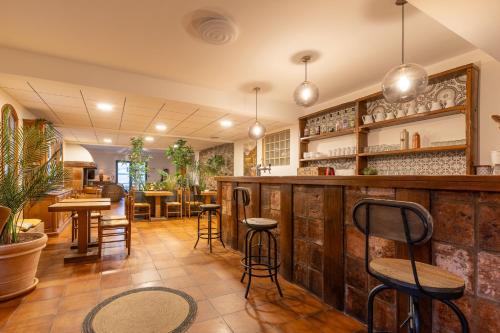 a restaurant with a bar with chairs and tables at L'Interlude in Mons