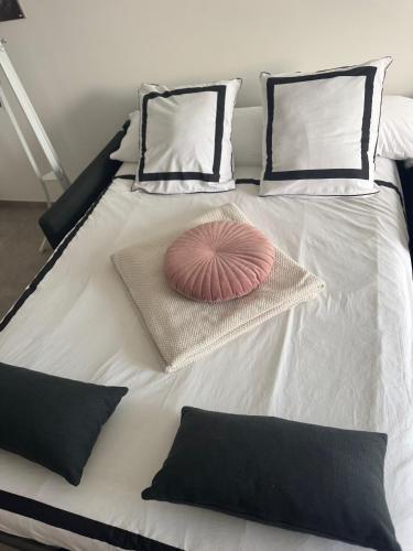 - un grand lit blanc avec un oreiller rose dans l'établissement La Lumière du Coeur, à Saint-Philbert-de-Bouaine