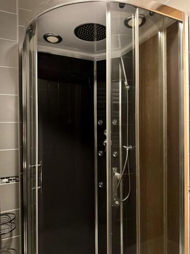 une douche avec une porte vitrée dans une salle de bain dans l'établissement Palais des Sources Vichy, à Vichy