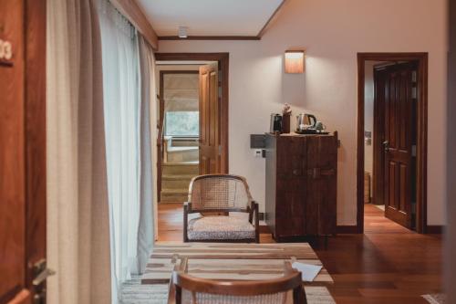 a room with a chair and a window and a door at Brij Atmanya Bhowali, Nainital, A Luxury Mountain Escape in Nainital