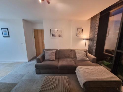 a living room with a brown couch in a room at Canal Side Flat by City SuperHost in Manchester