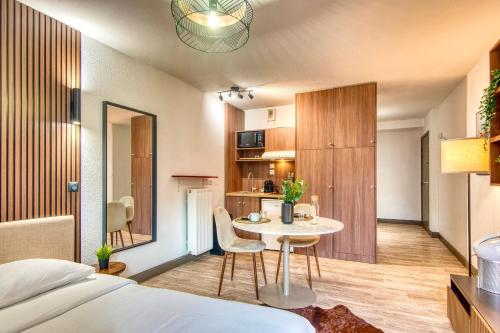 Cette chambre comprend un lit, une table et une cuisine. dans l'établissement La Suite Yak - Très beau studio - Charpennes-Tonkin, à Villeurbanne