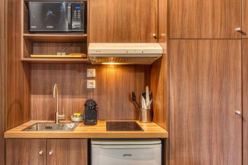 une petite cuisine avec un évier et un micro-ondes dans l'établissement La Suite Yak - Très beau studio - Charpennes-Tonkin, à Villeurbanne