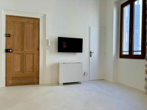 a room with a door and a tv on a wall at Studio du port - Porte marine in Antibes