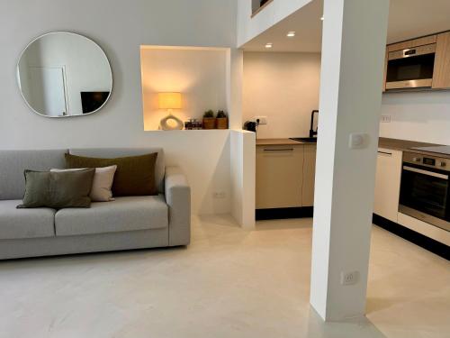 un salon avec un canapé et un miroir dans l'établissement Studio du port - Porte marine, à Antibes