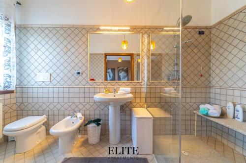 a bathroom with a sink and a toilet and a mirror at Lussuosa Villa con piscina a Porto Rotondo in Cugnana