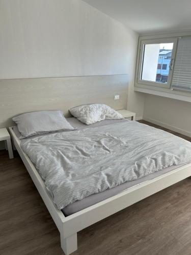 a white bed in a bedroom with a window at Punta Faro in Lignano Sabbiadoro