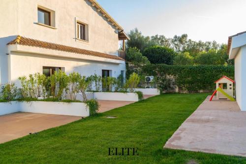 a yard with a house and a playground at Lussuosa Villa con piscina a Porto Rotondo in Cugnana