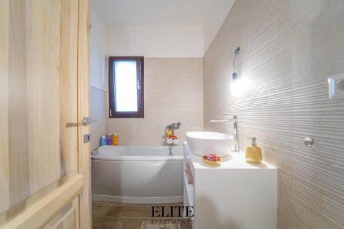 a bathroom with a white tub and a sink at Lussuosa Villa con piscina a Porto Rotondo in Cugnana