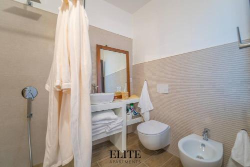 a bathroom with a sink and a toilet and a mirror at Lussuosa Villa con piscina a Porto Rotondo in Cugnana