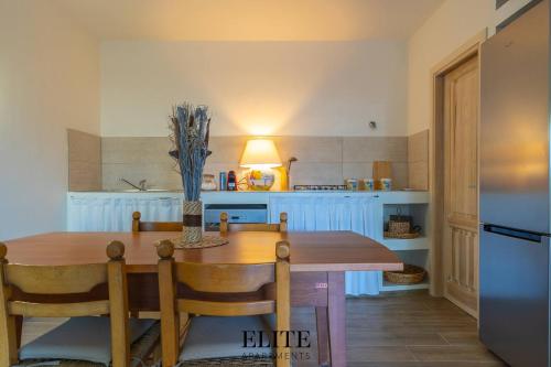 a kitchen with a wooden table and a refrigerator at Lussuosa Villa con piscina a Porto Rotondo in Cugnana