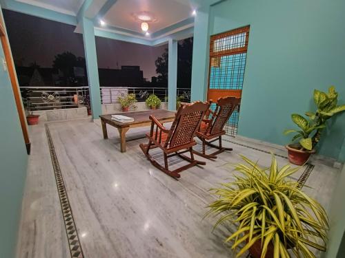 a porch with two chairs and a wooden table at Shri Ganesh Homestay in Prayagraj
