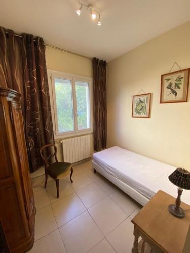 une chambre avec un lit, une chaise et une fenêtre dans l'établissement Maison de ville 4pers avec jardinet et garage - V0549, à Vias