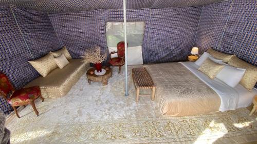 a bedroom with a bed and a couch at Dar Tawarta Guest House Dakhla in Dakhla
