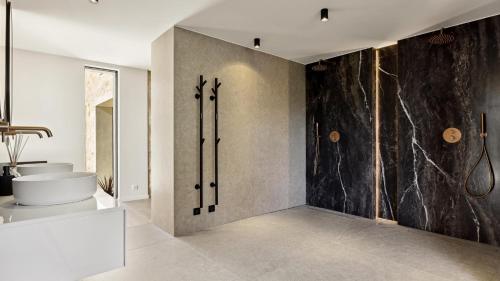 une salle de bain avec une baignoire et un lavabo et un mur dans l'établissement Villa à pied du Village de Mougins, à Mougins