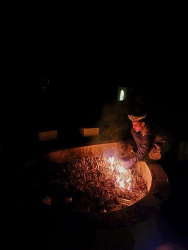 a boy is cooking over a fire in a fire pit at امان نيحامين سيوة Aman Nahmin siwa in Siwa
