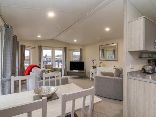 a kitchen and living room with a table and chairs at Longdon Lodge in Evesham