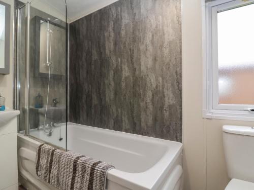 a bathroom with a shower and a tub and a sink at Longdon Lodge in Evesham