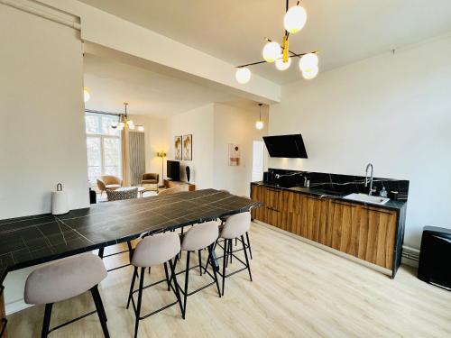 une cuisine et une salle à manger avec une grande table et des chaises dans l'établissement Hypercentre, quai de Loire, lumineux, spacieux, familial, le Jehan de Saveuse, à Blois
