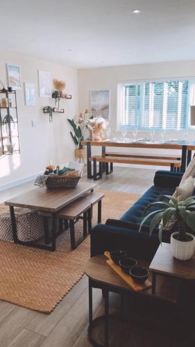 a living room with a blue couch and tables at No 1 The Paddock - Spacious holiday home with a hot tub in Bude