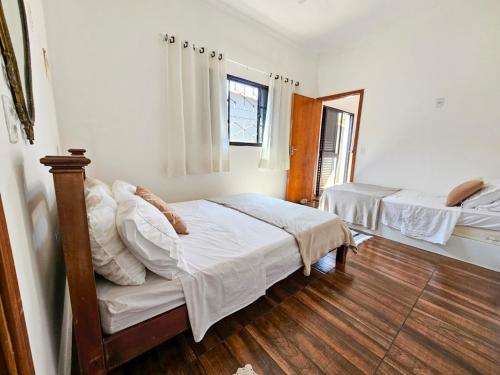 a bedroom with two beds and a mirror at Hospedagem Aconchegante em Brotas - Natureza e Conforto - Casa 2 in Brotas