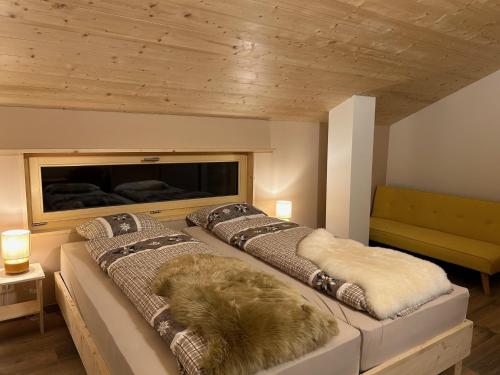 a bedroom with two beds with furry pillows at Agritourisme de Montagnier in Bagnes