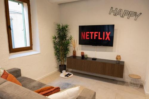 un salon avec un panneau Netflix joyeux sur le mur dans l'établissement Appartement familial au coeur du Vieil Antibes, à Antibes