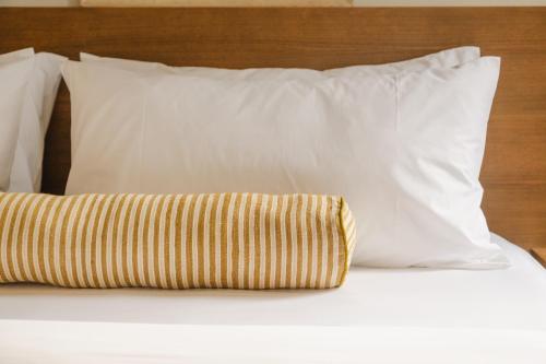 a pillow sitting on a bed with white pillows at The Belvedere Hotel - Kingston in Kingston