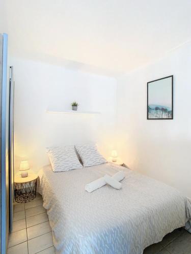- une chambre avec un lit avec une croix dans l'établissement Palladium - Studio 40m2 - 10 min Palais - Climatisé, à Cannes