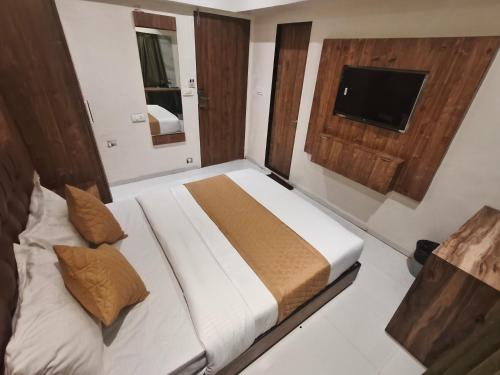 a bedroom with a large bed and a television at Hotel West Line Andheri in Mumbai