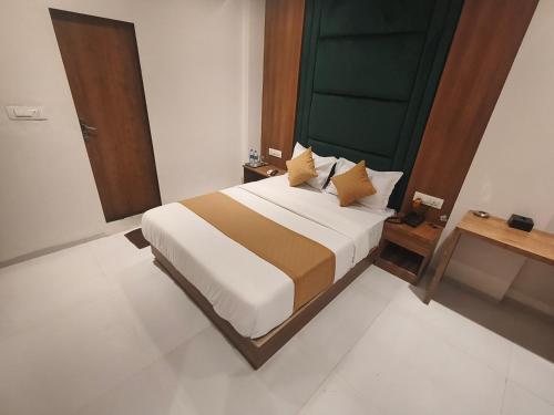 a bedroom with a large bed and a green door at Hotel West Line Andheri in Mumbai