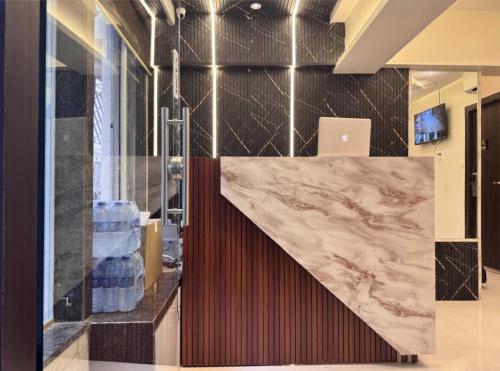 a lobby with a large marble counter and aaptop at Hotel West Line Andheri in Mumbai