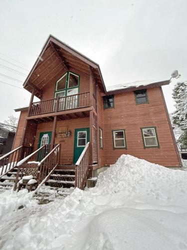 una casa con un montón de nieve delante de ella en 白馬の小家ー203室, en Hakuba