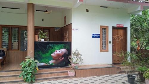 a large tv on the side of a building at Kailasahomestay & Ayurvedic Spa in Pūvār